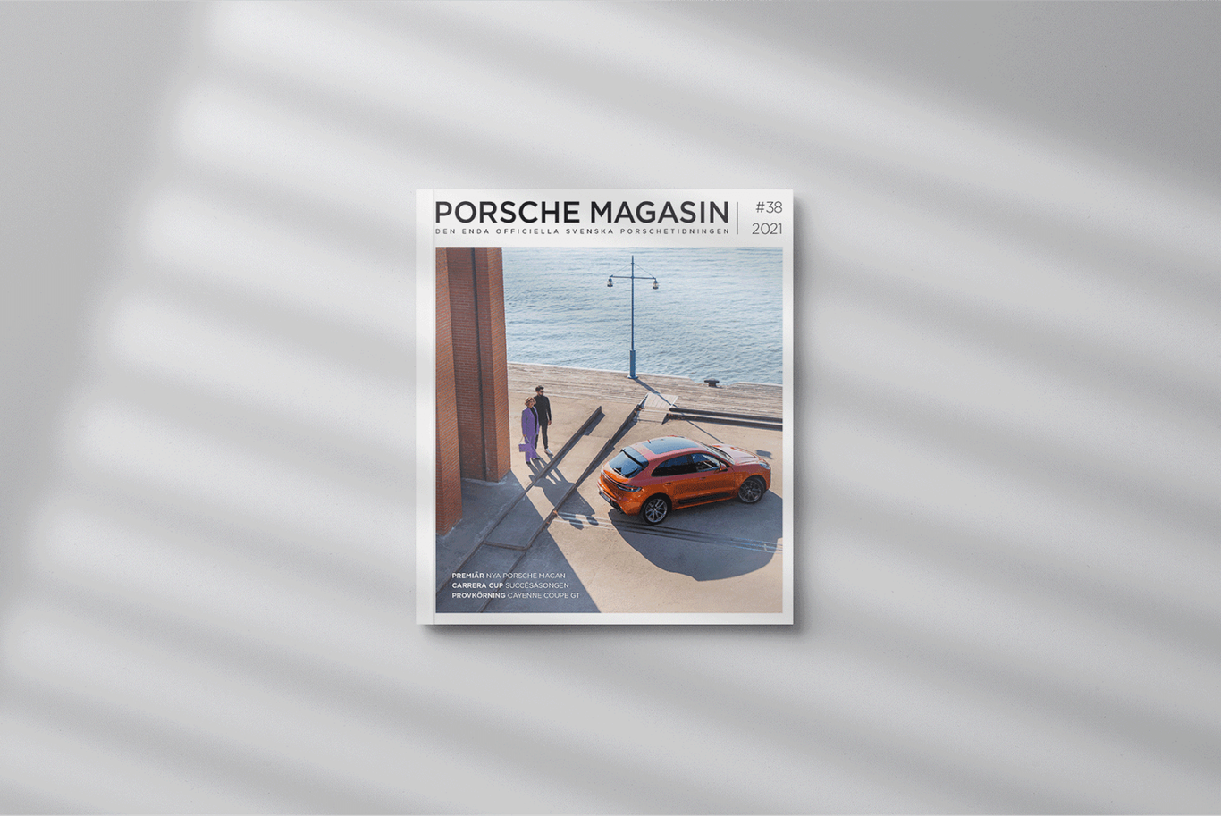 The cover of porsche magzine with a car on it.