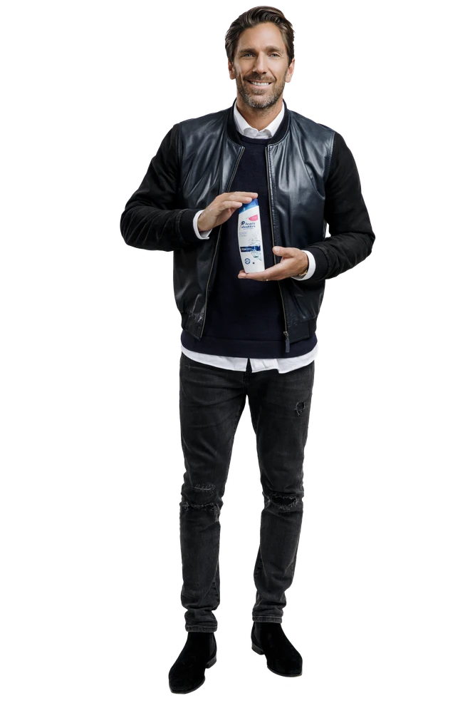 A man holding a bottle of shampoo.