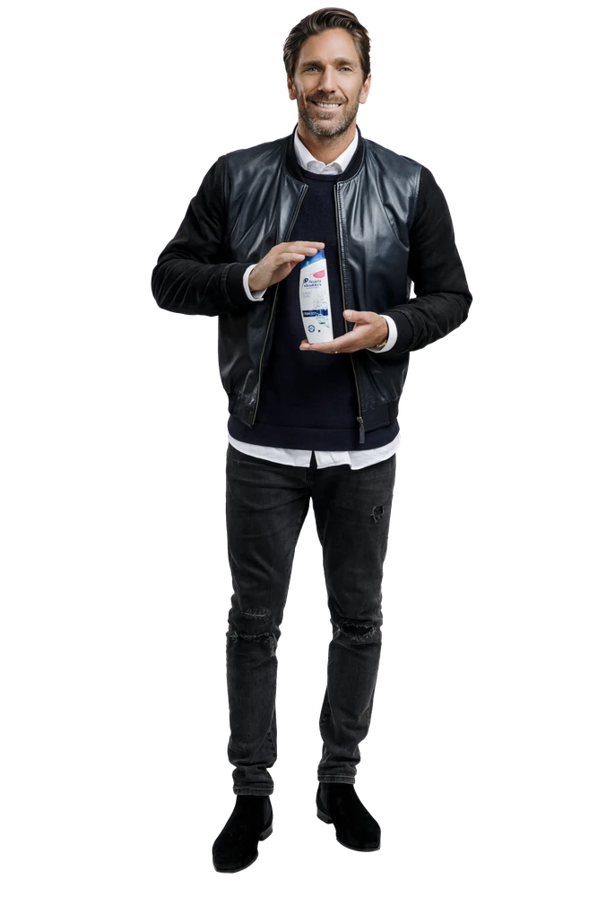 A man holding a bottle of shampoo.